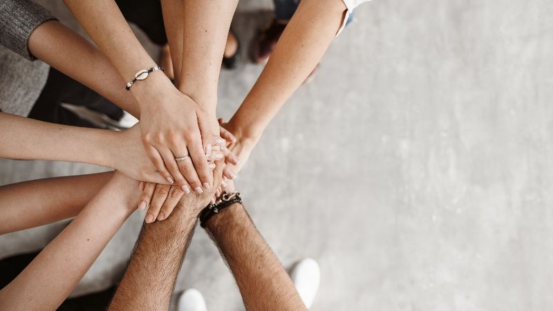 Menschen führen Hände zusammen und besiegeln Zusammenarbeit
