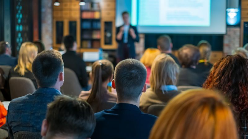 Sitzendes Publikum vor stehendem Vortragenden