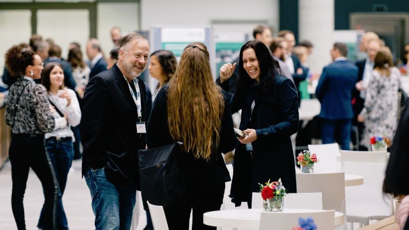 Personengruppe stehend und Blumen auf Tischen