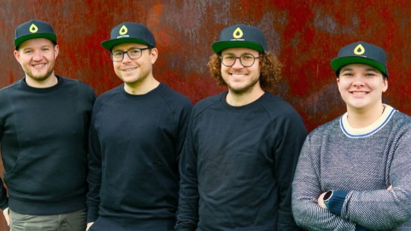 Vier Gründende schauen in die Kamera