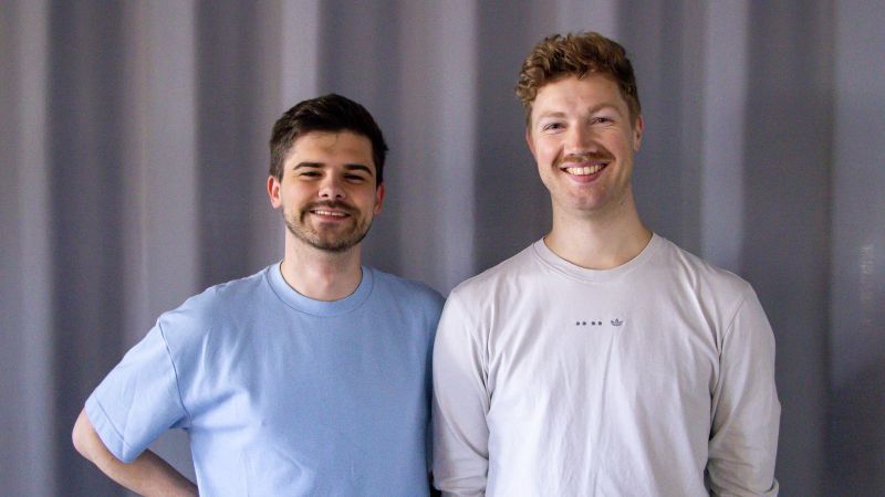 Die beiden jungen Gründer blicken lächelnd in die Kamera. Lukas Jan Talar hat kurze rotblonde Haare und ein weißes T-Shirt. Lukas Jan Talar hat kurze dunkle Haare und einen Bart und ein hellblaues T-Shirt.