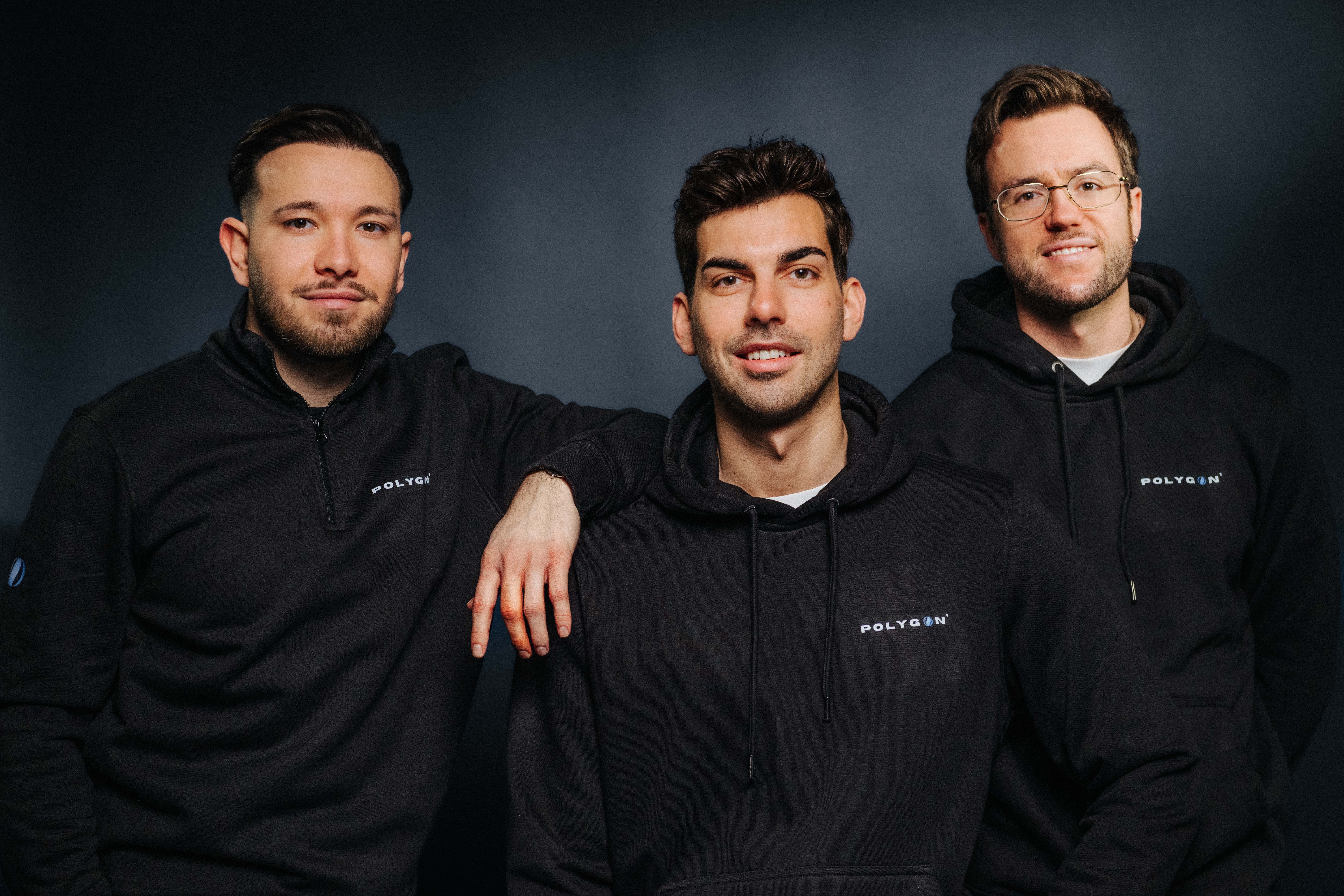 Die drei Gründer in schwarzen Hoodies mit Firmenlogo schauen in die Kamera
