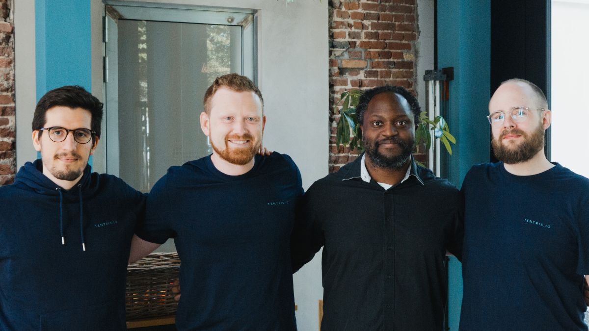 Vier junge Männer stehen nebeneinander und blicken in die Kamera